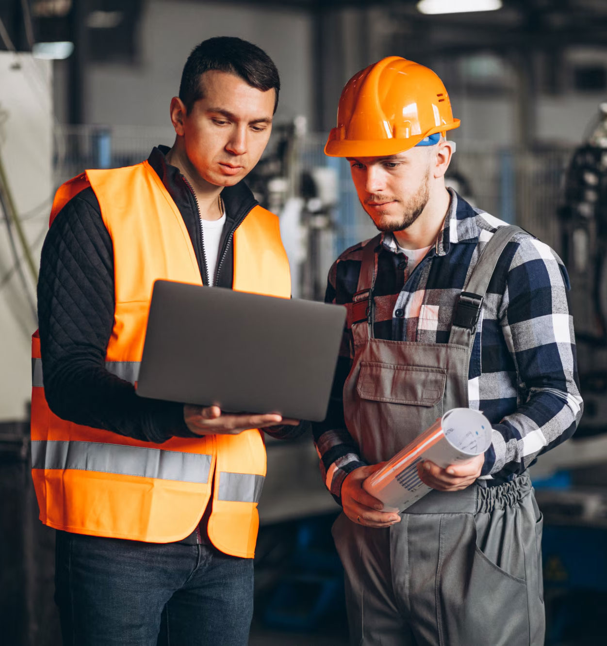 Deux équipiers dans une usine moderne qui supervise la maintenance des machines
